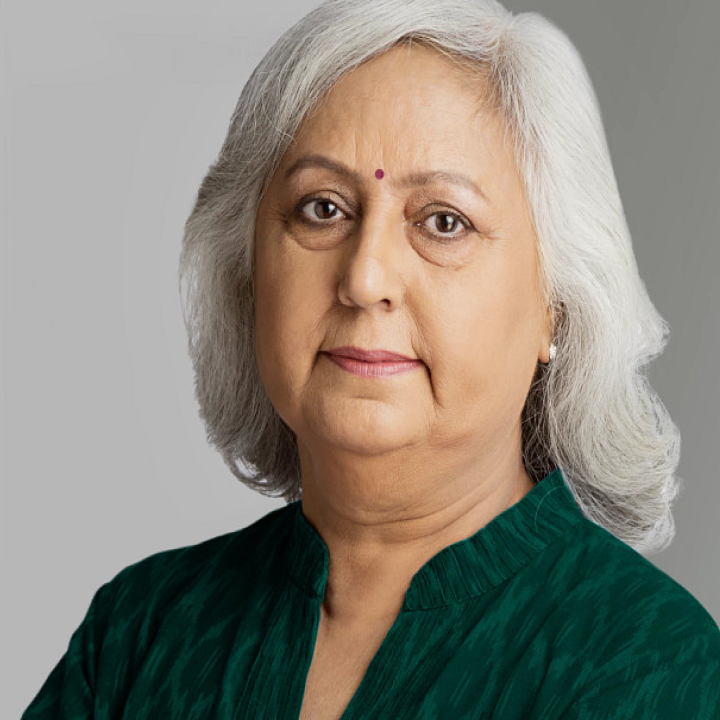 woman with white hair and green shirt looking at you