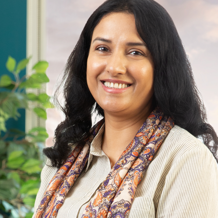 woman in a striped shirt and pattern scarf smiling