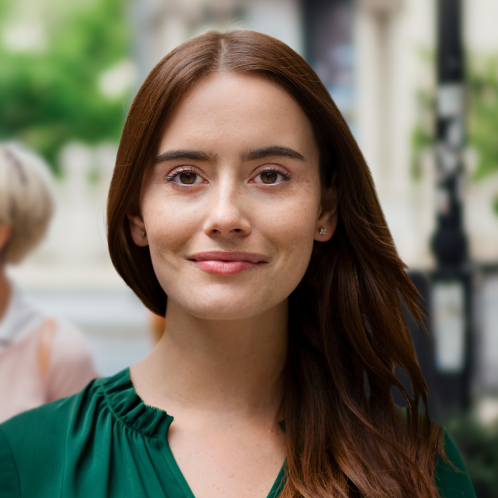 brunette woman walking down the street with a with woman with short blonde hair behind in the background