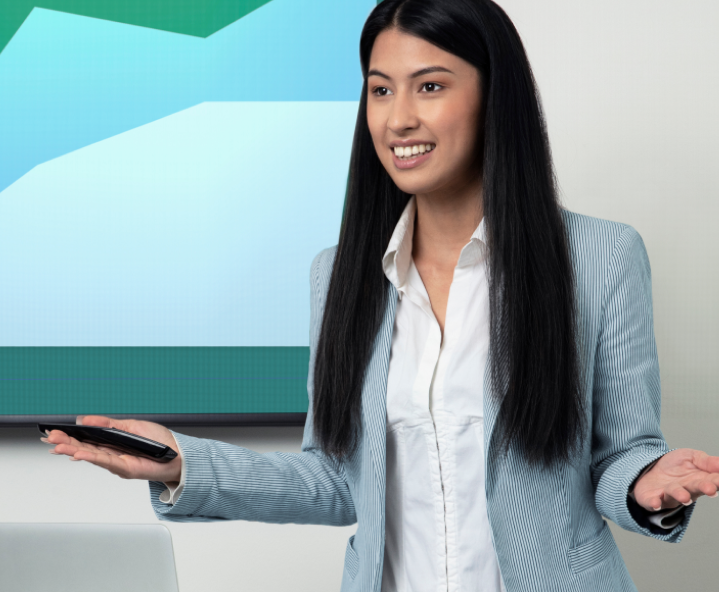 woman with long black hair and blue pinstripe blazer presenting in front of a screen