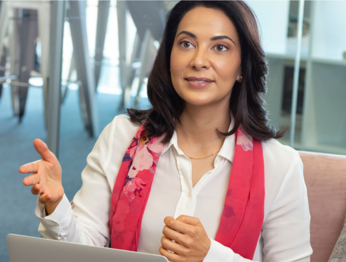 woman in a white shirt and pink scarf with a laptop