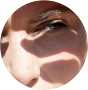 close up of a woman shileding her face from the sun with her hand