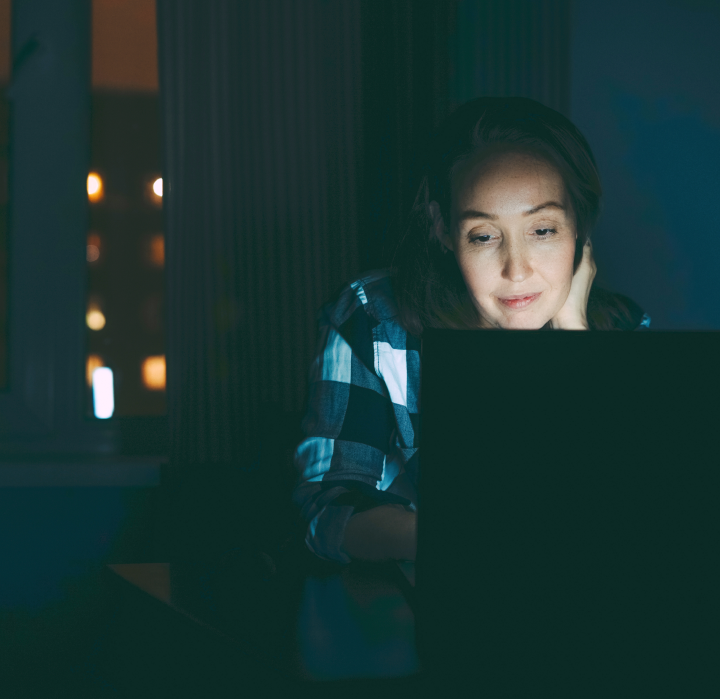 woman looking at a computer screen at night experiences digital eye strain