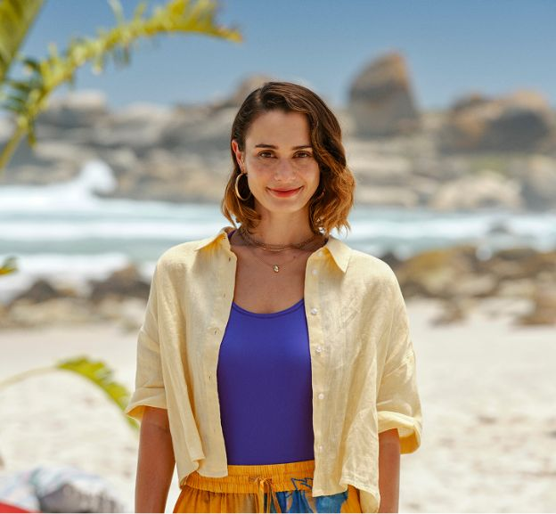 Woman on the beach smiling and looking directly at the camera