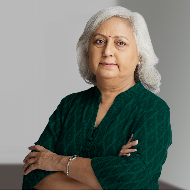 Mujer mayor mirando a la cámara con una blusa verde con detalles y un bindi en la frente