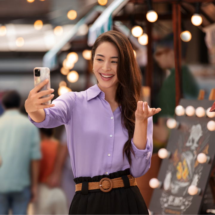 Woman smiling while taking  selfie with her phone to discover if she may have symptoms of dry eye