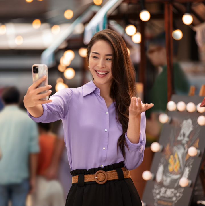 Woman smiling while taking selfie with her phone to discover if she may have symptoms of dry eye