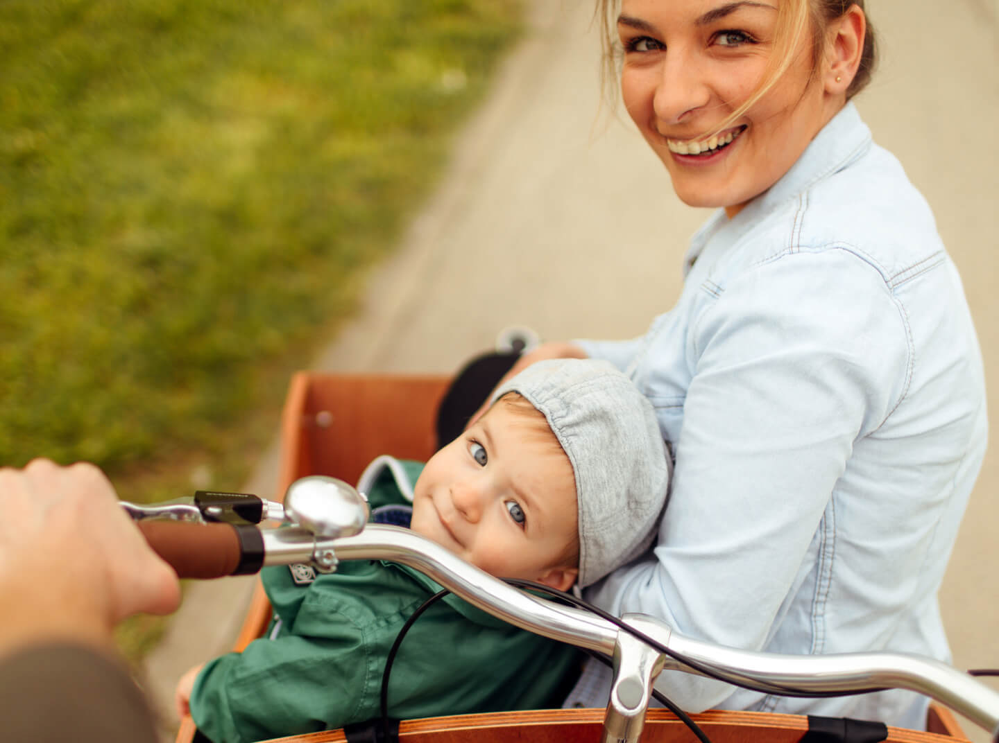 mosolygós anya és fia néz vissza a kamerába, miközben lovaglás kerékpároznak
