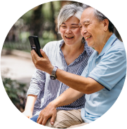 Elderly couple smiling looking at phone