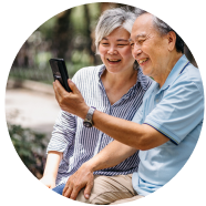 Elderly couple smiling looking at phone