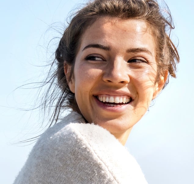 A smiling woman looking back over her shoulder